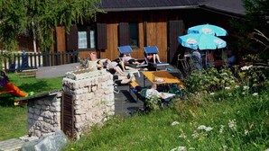 A lodge with outdoor seating and a stone structure. - Residence Prada (Trento)