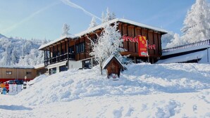 A wooden building with a sign for 'Prado Bar & Restaurant' and a small wooden structure in the foreground. - Residence Prada (Trento)