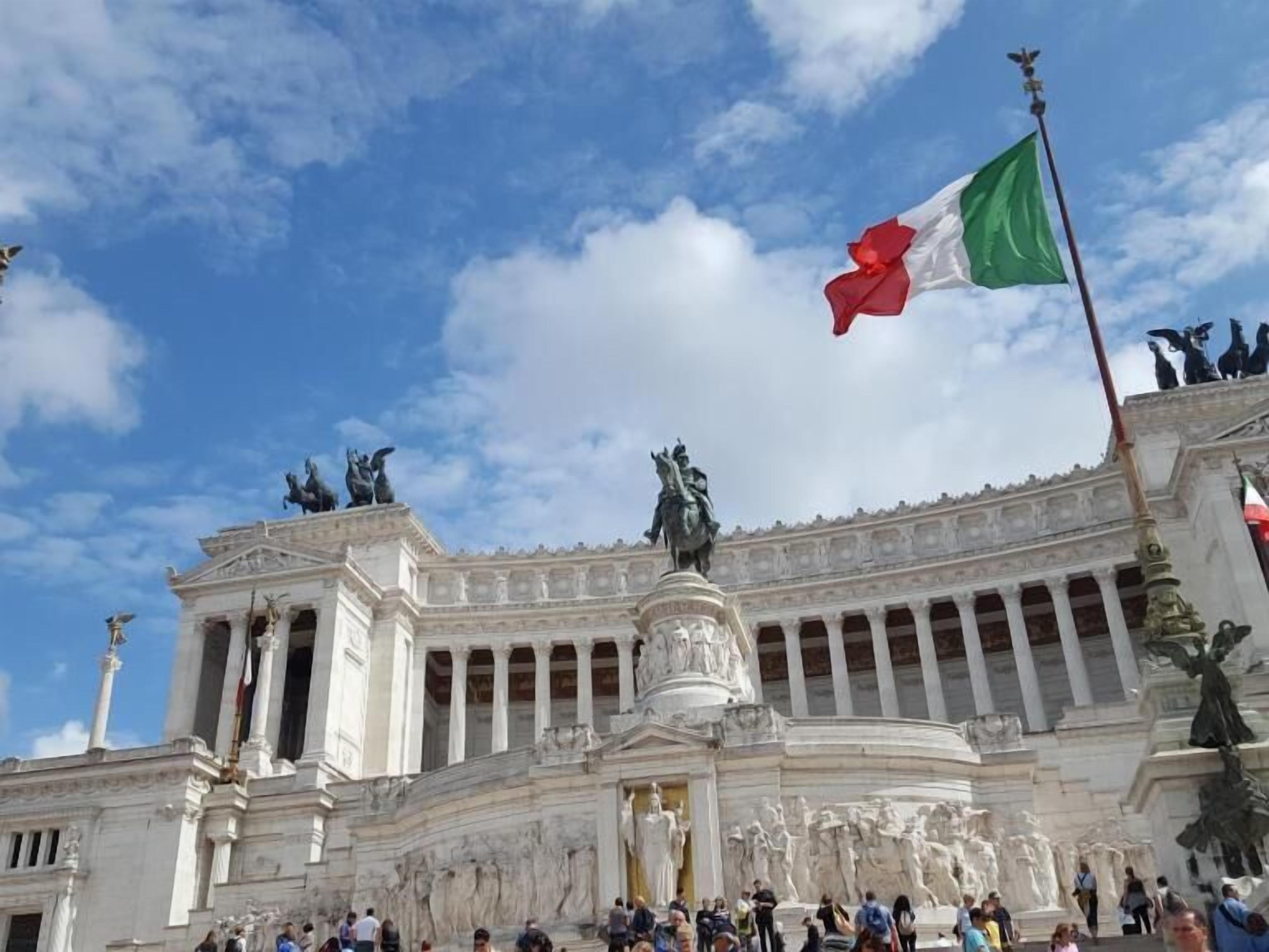 A large public building with classical architecture, featuring columns and statues.