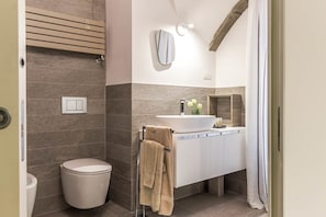 A modern bathroom with a toilet, sink, and towel rack.