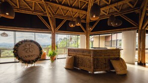 Una habitación amplia con techo alto, ventanas grandes y una mesa de recepción.