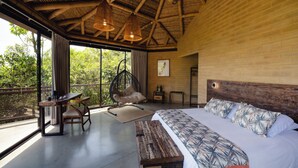 Un dormitorio amplio con una cama grande, techo de madera y vistas al exterior.