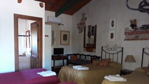 A room with two beds, a television, and a window.