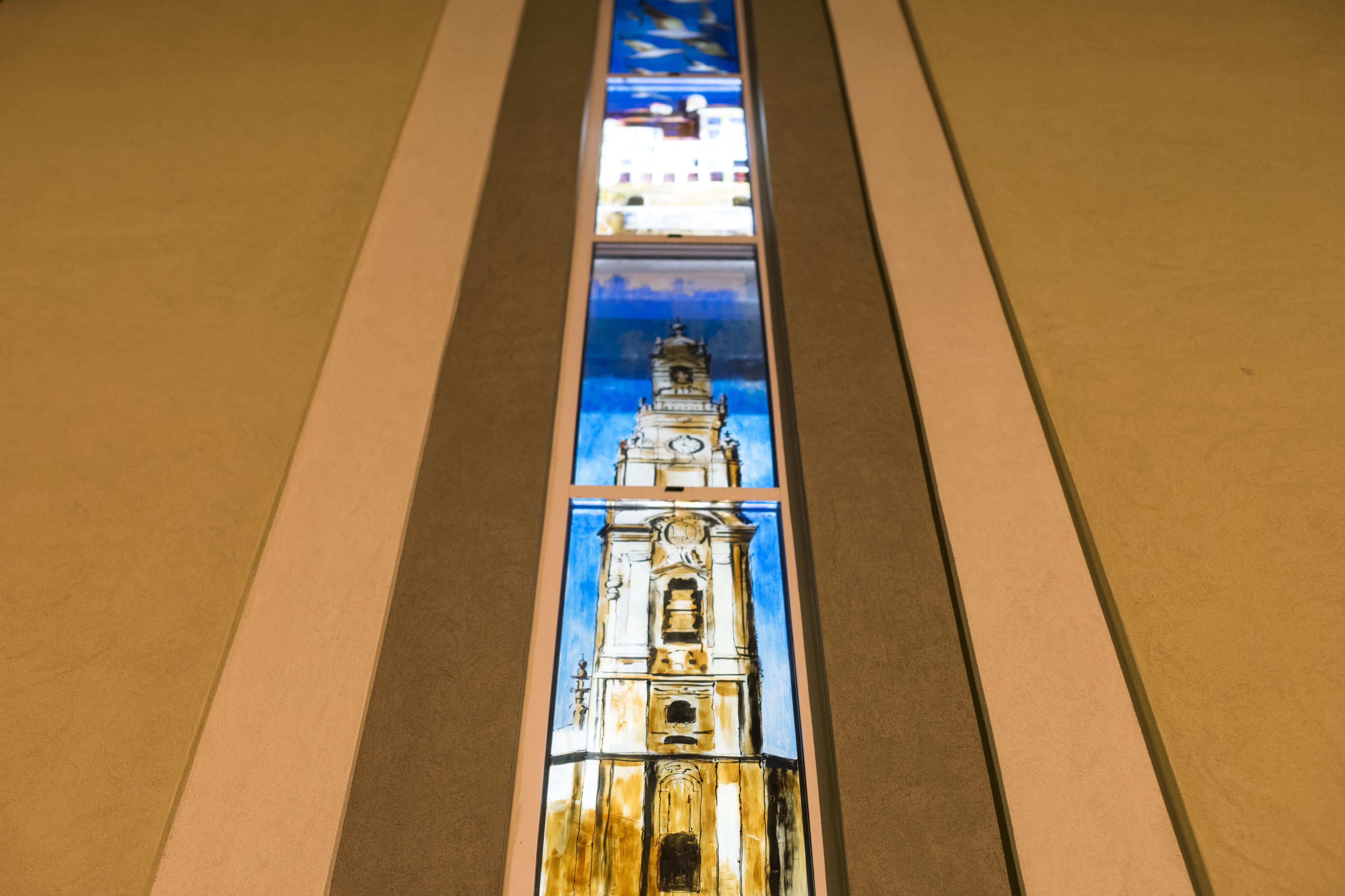A stained glass window with a clock tower design.