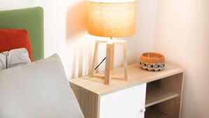 A bedside table with a lamp, a bowl, and pillows. - Secret Garden Via San Rocco - Flat in Bo (Bologna)