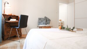 A bedroom with a bed, a chair, a desk, a lamp, a plant, and a book. - Secret Garden Via San Rocco - Flat in Bo (Bologna)