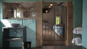 Une salle de bain équipée d’un lavabo, d’un miroir et d’un espace douche.