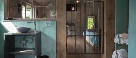 Une salle de bain équipée d’un lavabo, d’un miroir et d’un espace douche.