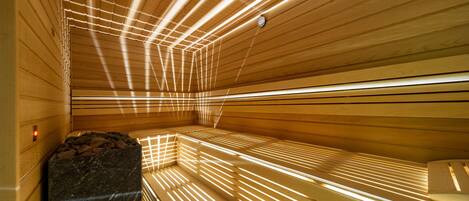 A sauna with wooden slats and a marble bench.
