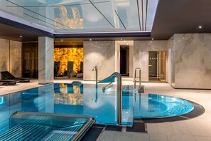 A modern indoor swimming pool with a glass ceiling, a hot tub, and a spa area. - Radisson Hotel & Apartments Gdansk (Gdansk)