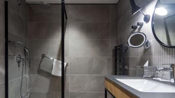 Un bagno moderno con box doccia in vetro, un mobile bagno in legno con lavandino e uno specchio.