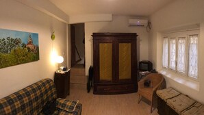 A compact living room with a sofa, a small table, a television, and a cabinet. - Studio Hosts 2 Via Dè Ruini - Flat in Bo (Bologna)