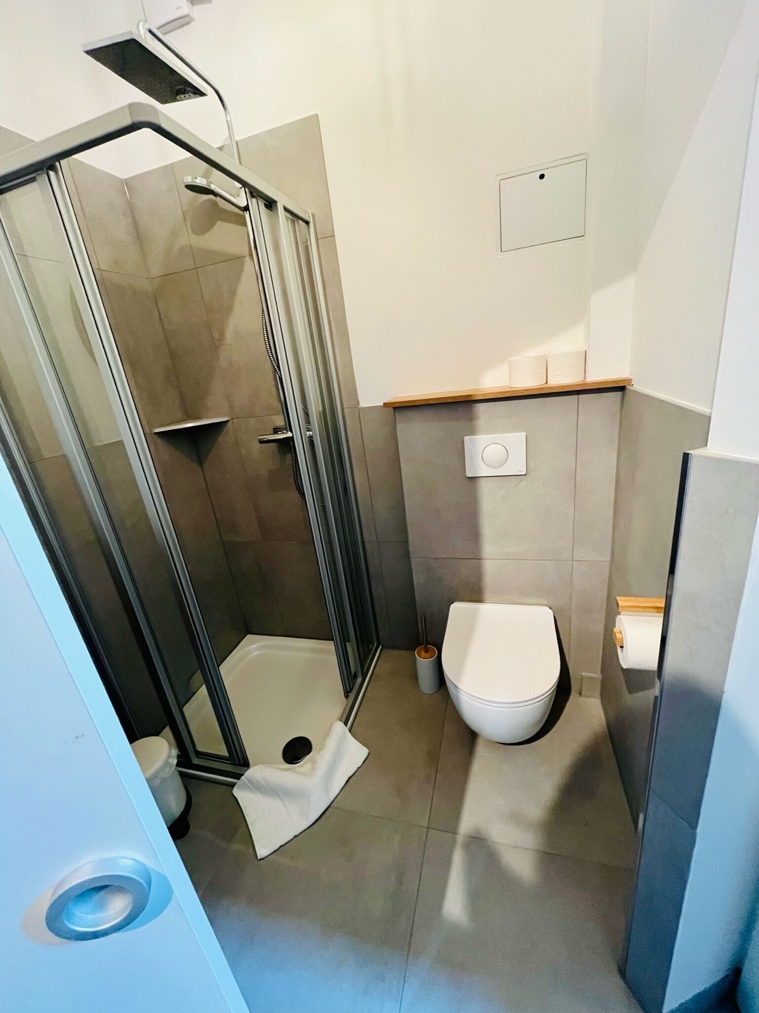 Un baño moderno con ducha acristalada, inodoro y lavabo.