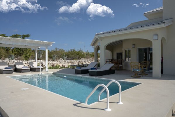 Alberca al aire libre y camastros 