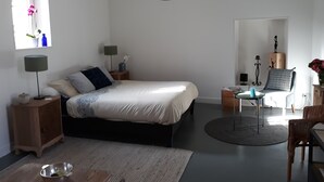Een moderne slaapkamer met een bed, nachtkastjes, een bureau en een stoel.