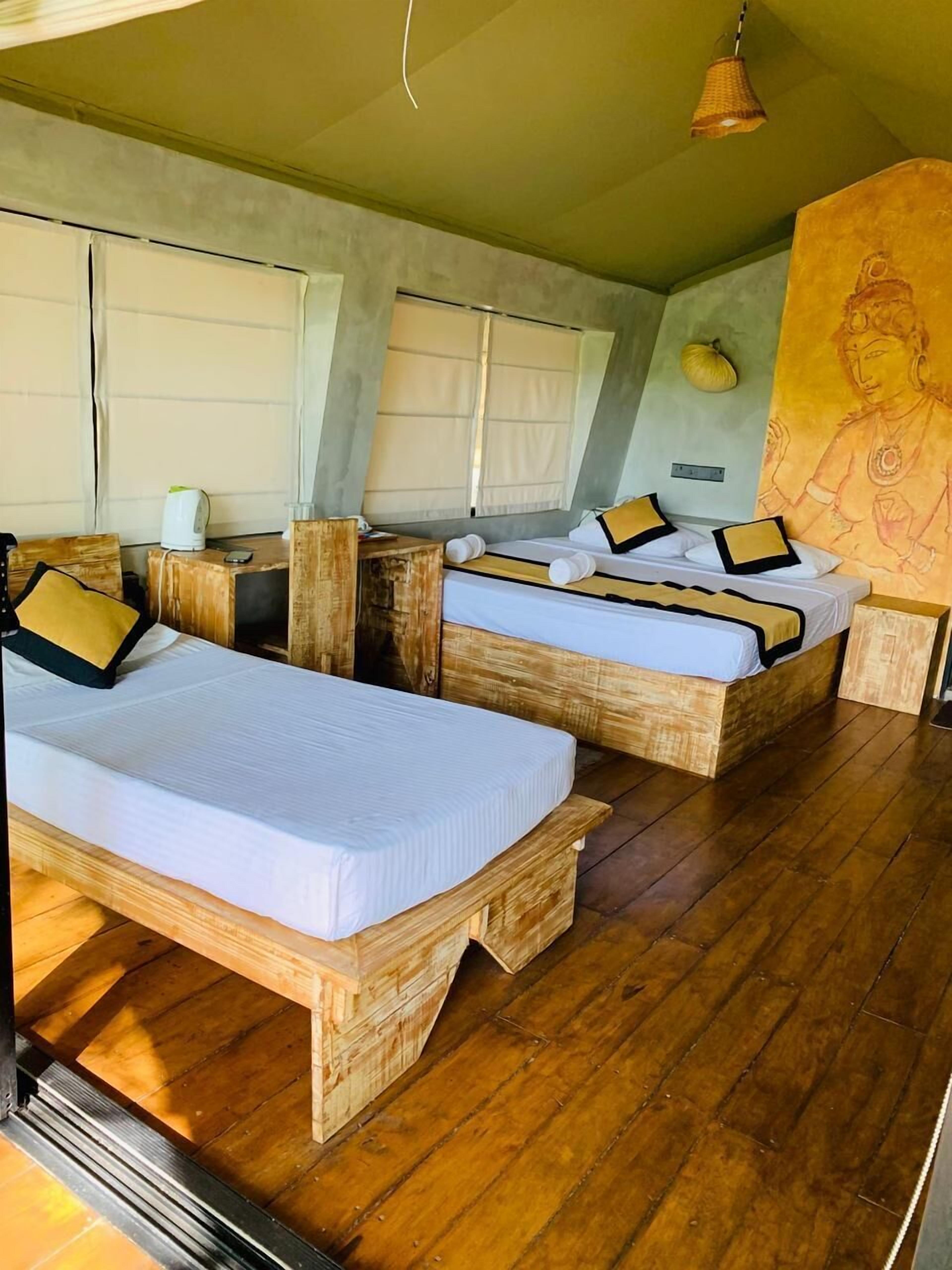 Une pièce avec deux lits en bois, une grande fresque murale et un plancher en bois.