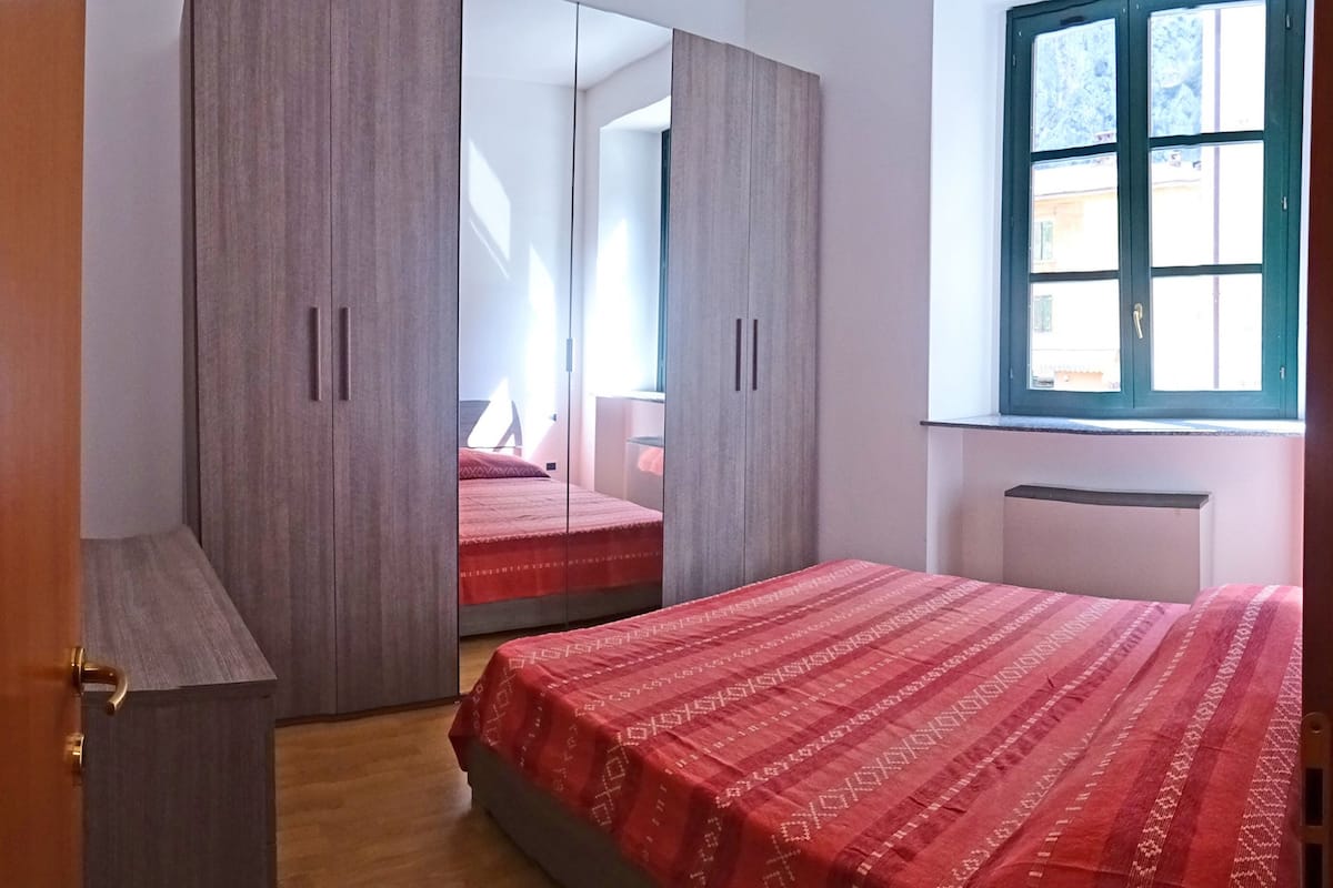 Ein Schlafzimmer mit Bett, Kleiderschrank und Fenster.