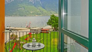 A balcony with a view of a lake, mountains, and a playground. - Holideal Campione Bed & Surf (Tremosine)
