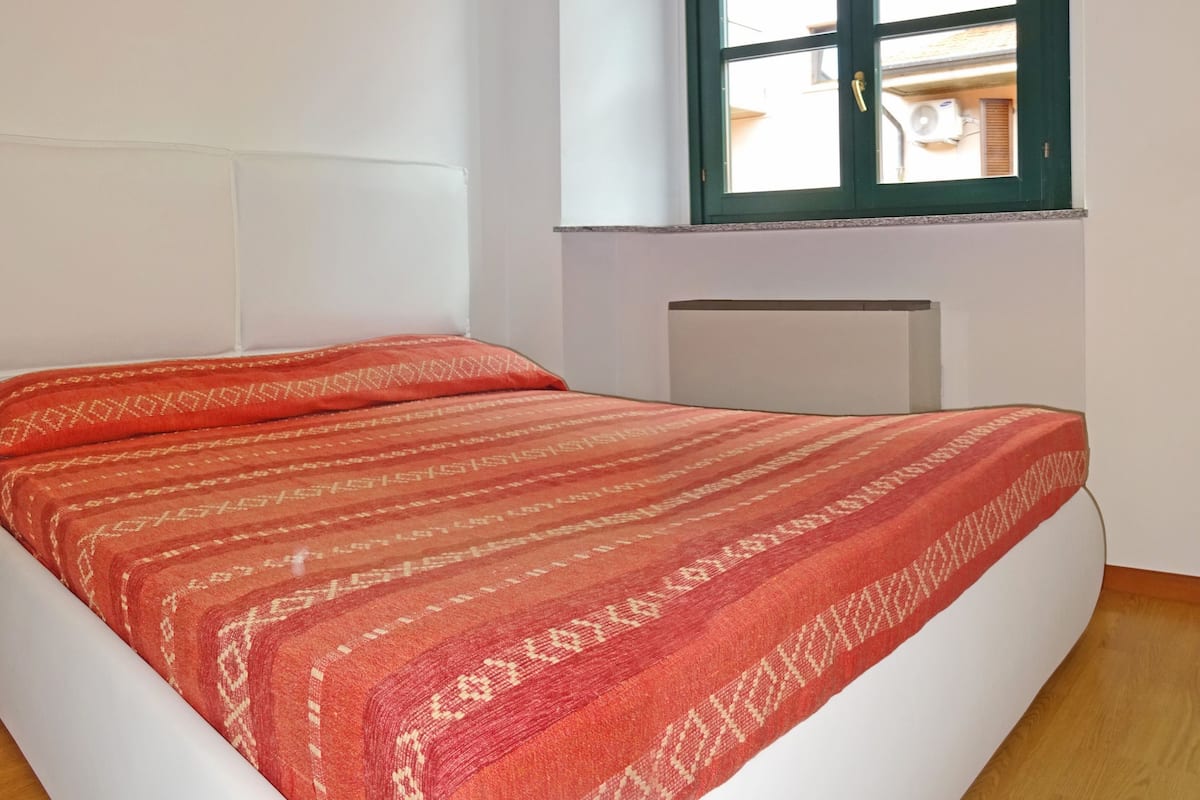 Ein Zimmer mit Bett, Fenster und Heizkörper.