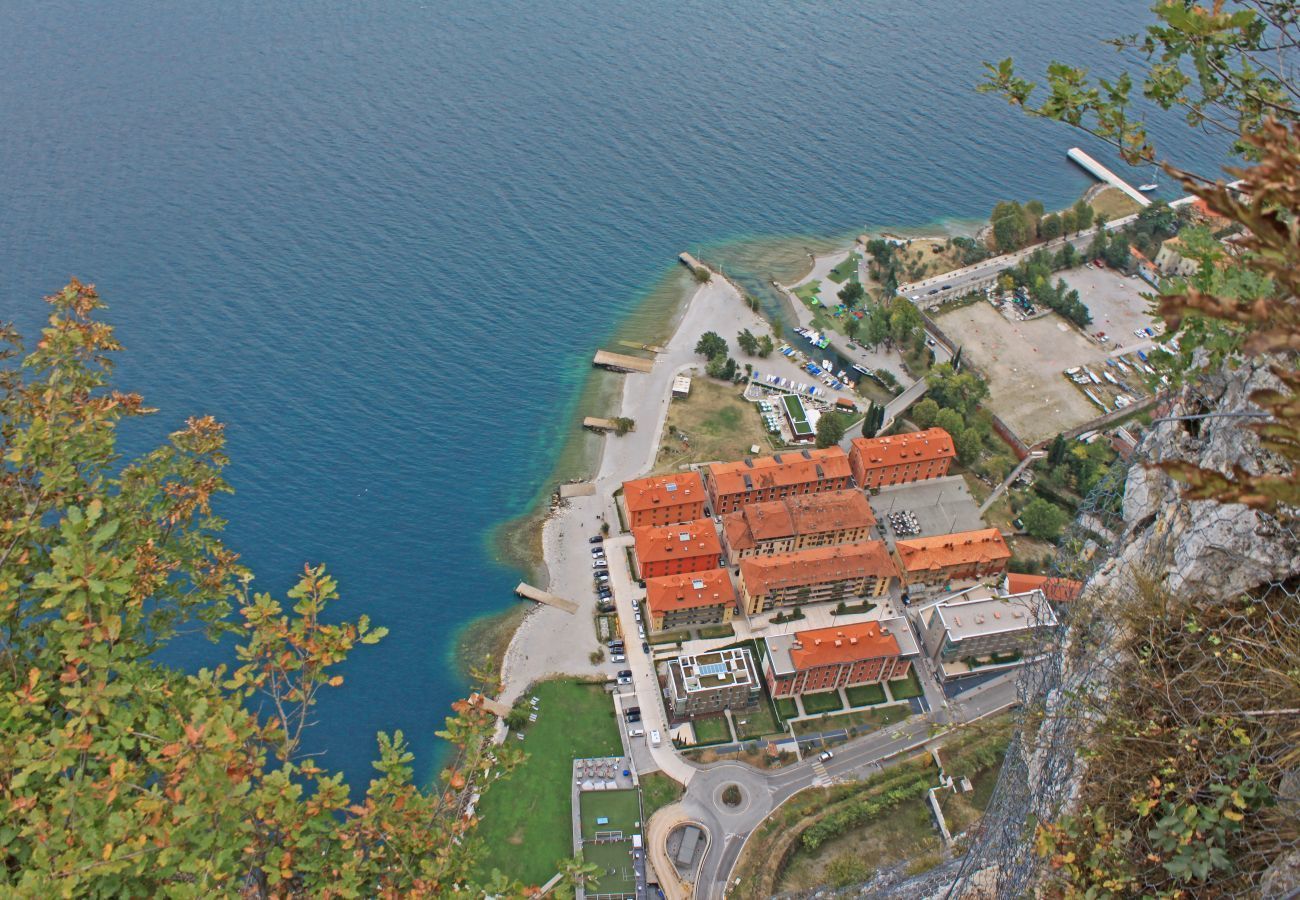 A coastal town with red-roofed buildings, a marina, and a clear view of the sea.