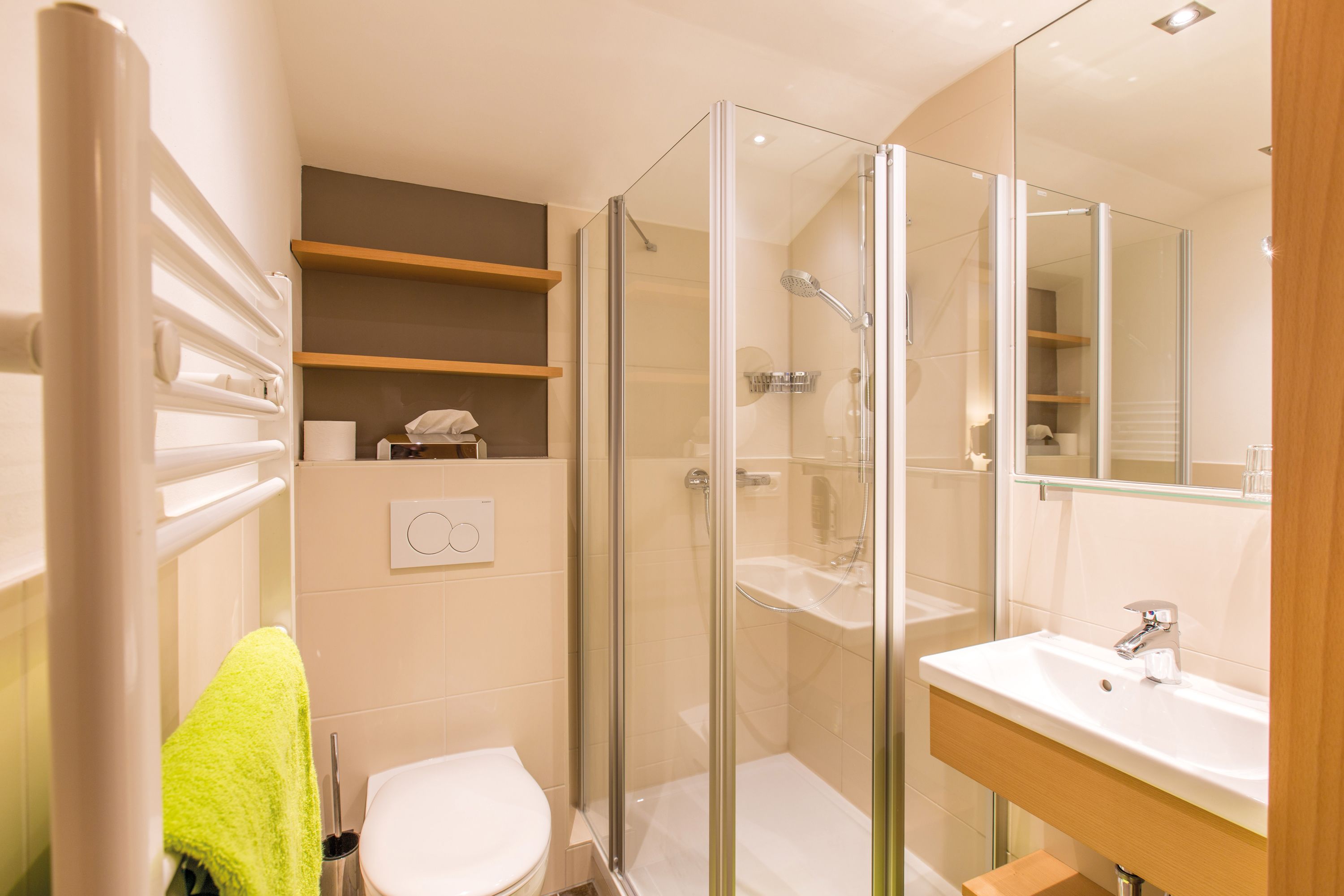 Ein modernes Badezimmer mit einer Duschkabine, einem weißen Waschbecken und einer Toilette.