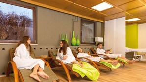 A room with four reclining chairs, each occupied by a person in a white robe.