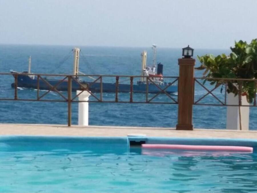 Une piscine offrant une vue sur l’océan et les navires qui se dessinent à l’horizon.