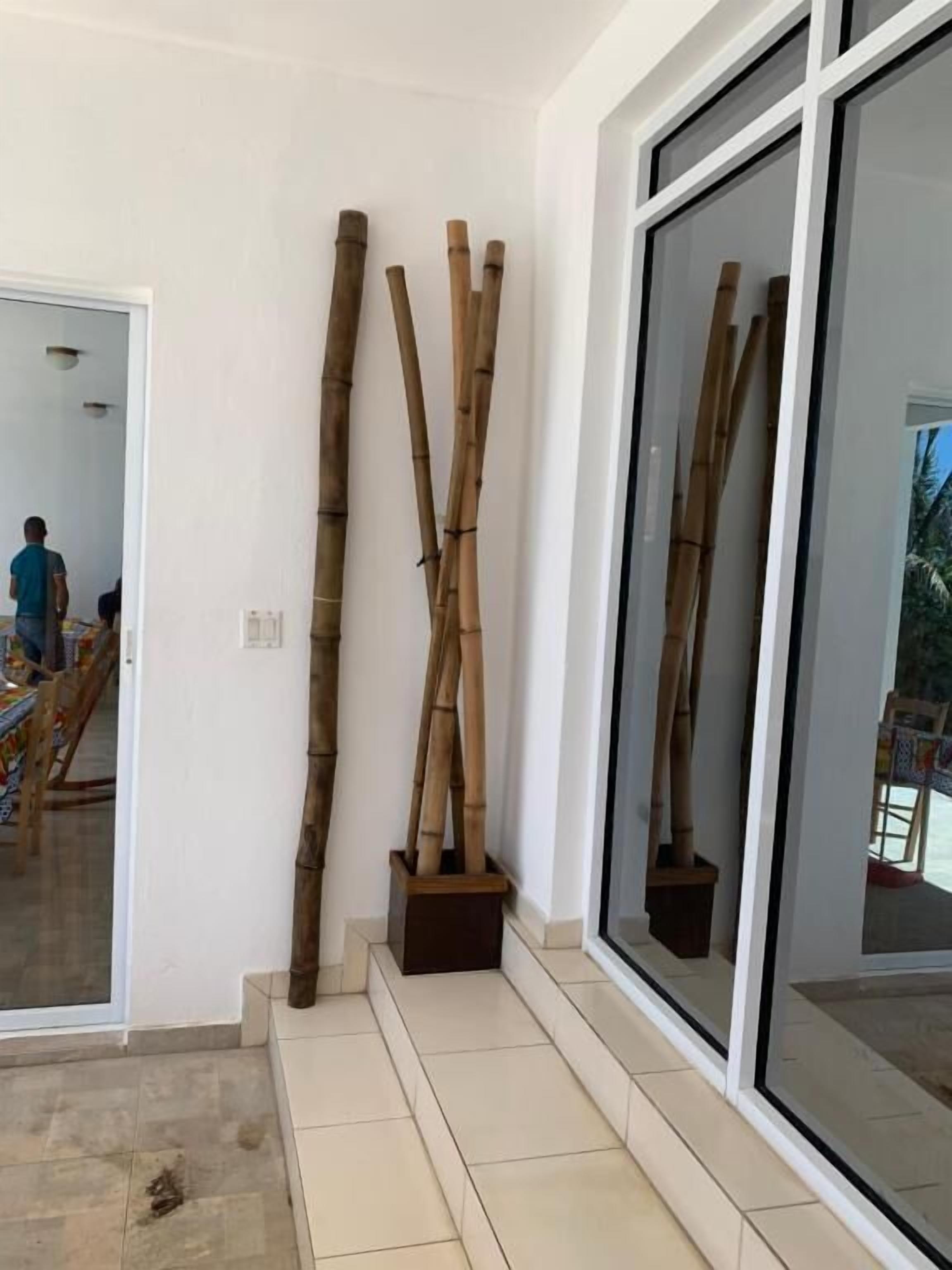 A room with a large window, a tiled floor, and bamboo decorations.