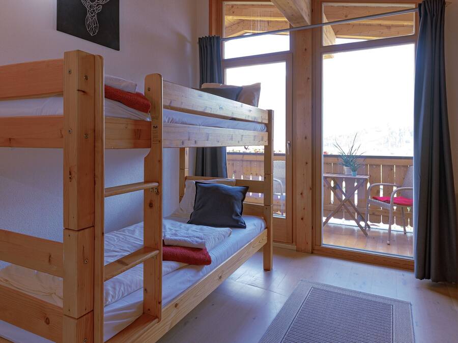 Habitación con literas de madera y vistas al exterior.