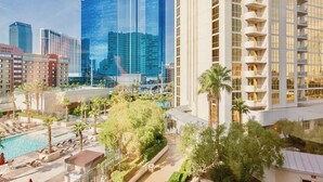 A hotel with a rooftop pool, palm trees, and modern buildings in the background. - No Resort Fee | Strip Views, Pools & Parking (Las Vegas)