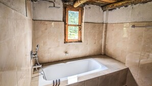 A bathroom with a bathtub, a window, and a shower. - Kyirmu Lodge Phaplu (Phaplu)