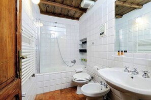 Ein Badezimmer mit Dusche, Toilette, Bidet und Waschbecken.