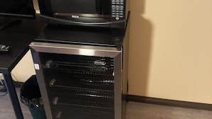 A compact kitchenette with a microwave and a built-in oven.