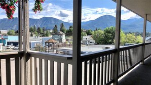A balcony with a view of a town and mountains.