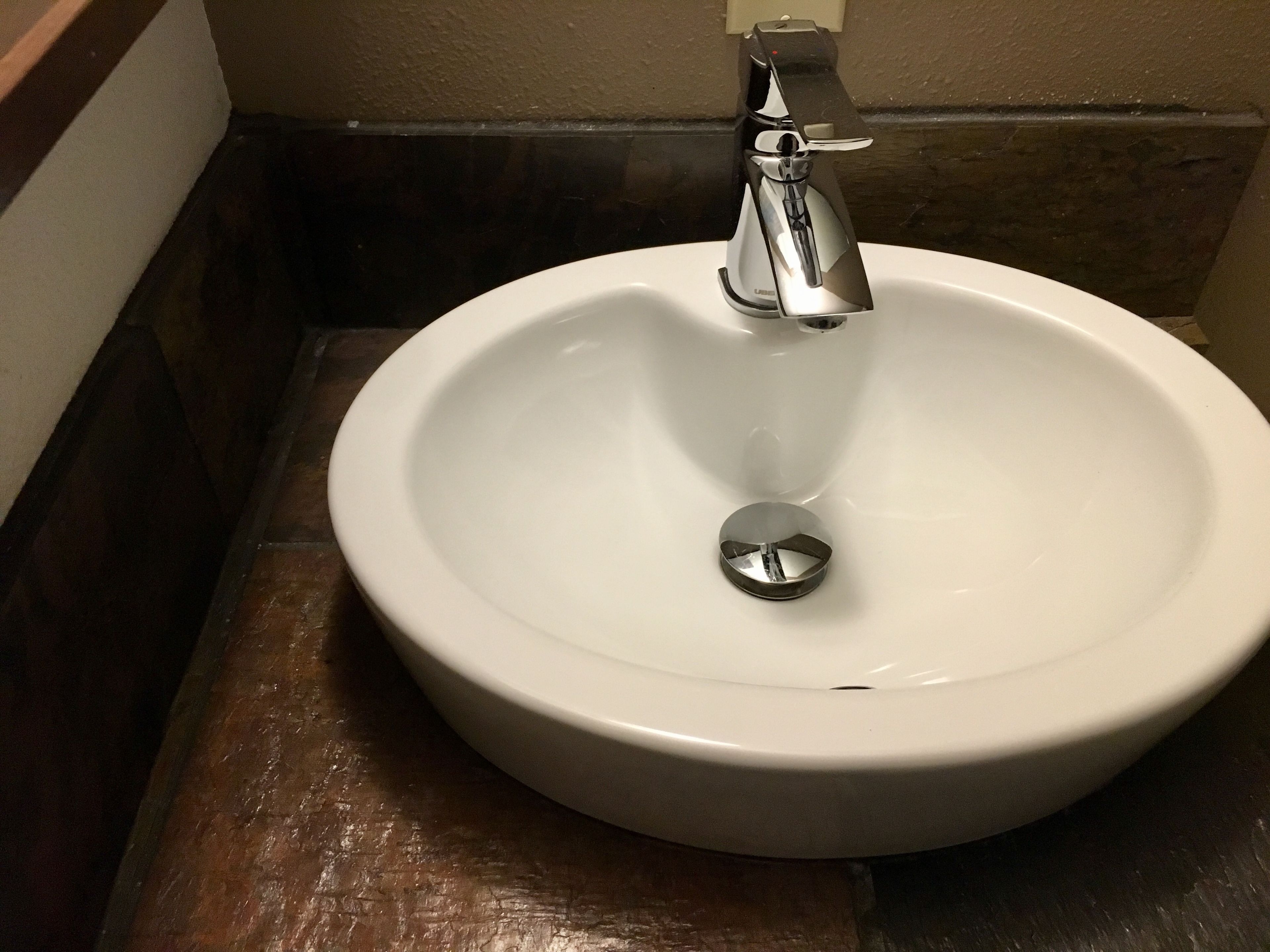 Un lavamanos de cerámica blanca con un solo grifo en un baño.