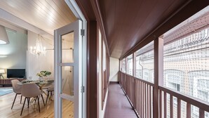 Ein modernes Interieur mit Essbereich, einer Deckenleuchte und einem Balkon mit Blick auf die Stadt.