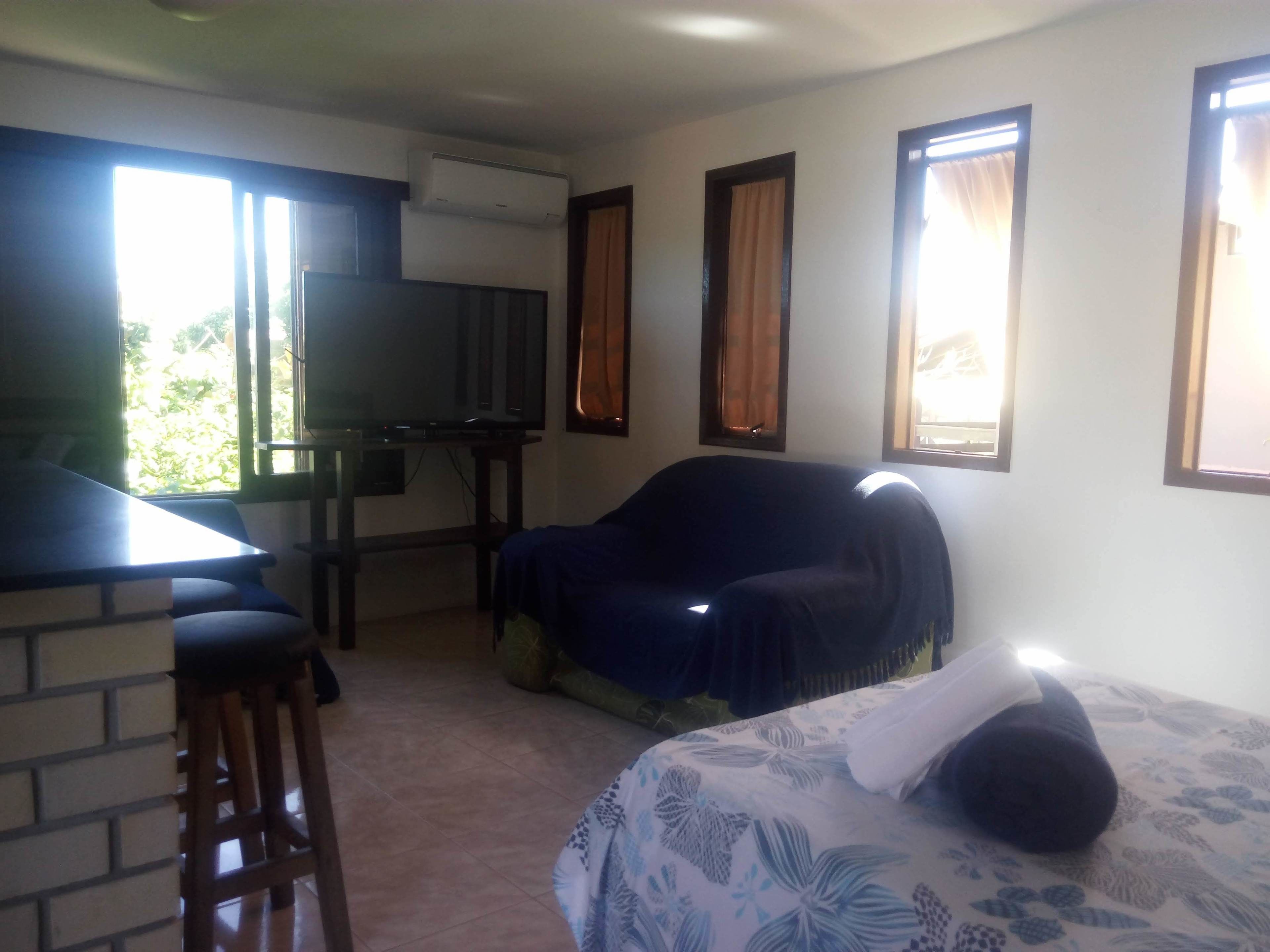 A room with a bed, a desk, a chair, and a television.
