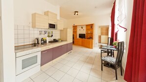 A modern kitchen with a dining area, featuring a microwave, kettle, and various utensils. - Apartment No. 14 in Vienna near Schönbrunn/Westbahnhof | Keyless Check-In (Rudolfsheim-Fünfhaus)