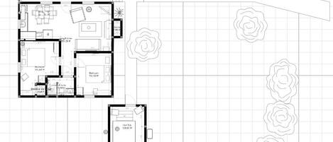 Plano de planta de un hotel que incluye un dormitorio principal, baño, cocina, comedor y un pequeño balcón.