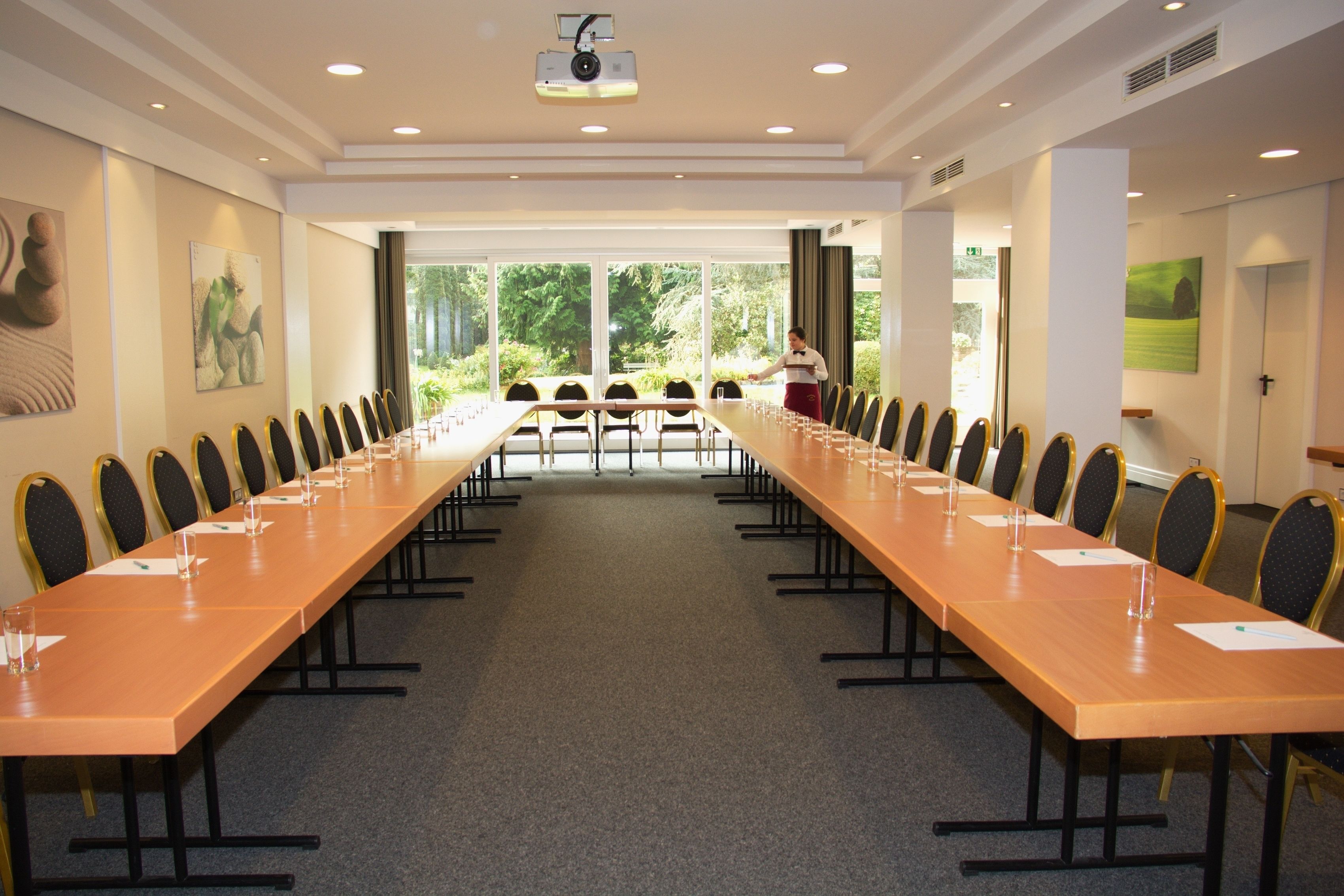 A conference room with a long table, chairs, and a projector.