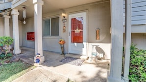 A residential building with a porch, a welcome sign, a mailbox, and a small garden area. - Stay in a classically designed apt near ORU, exercise trails, and restaurants! (Tulsa)