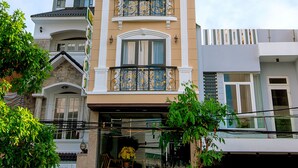 A multi-story hotel with balconies, a storefront, and a clear sky. - Hodi Hotel (Da Nang)