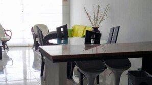 A conference room with a long table, four chairs, and a potted plant. - Apartamento Familiar (San Andrés)