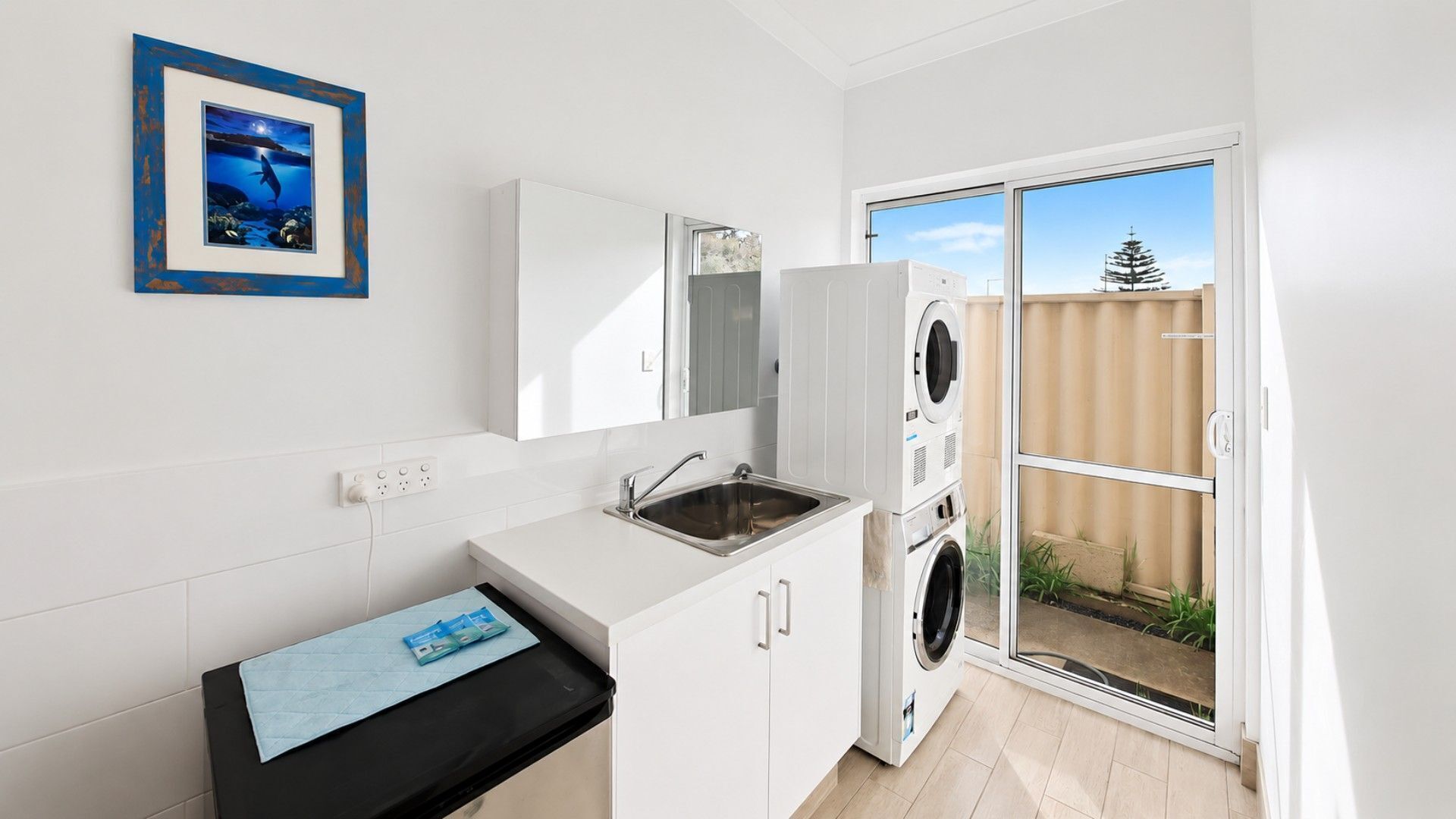 A compact kitchen with a sink, a countertop, and a built-in washing machine.