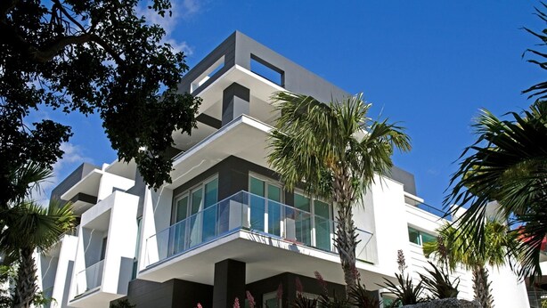 Un edificio moderno de varios pisos con balcones y ventanas amplias.