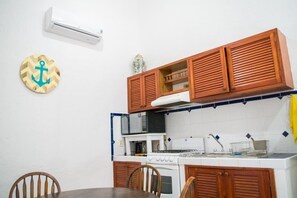 Kitchen area with microwave, stove, and sink, featuring a simple layout and ample counter space.
