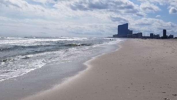 A beach with a city skyline in the background.