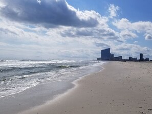 Una playa con un horizonte urbano al fondo.