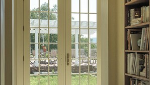 Ein geräumiges Zimmer mit einem großen Glastür zur Terrasse.
