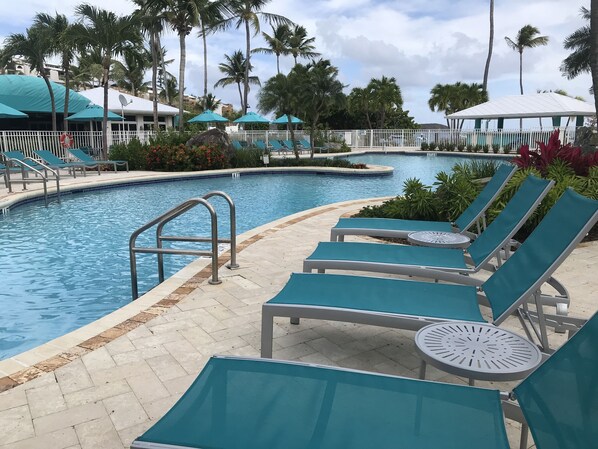 A poolside area with lounge chairs and a pool.